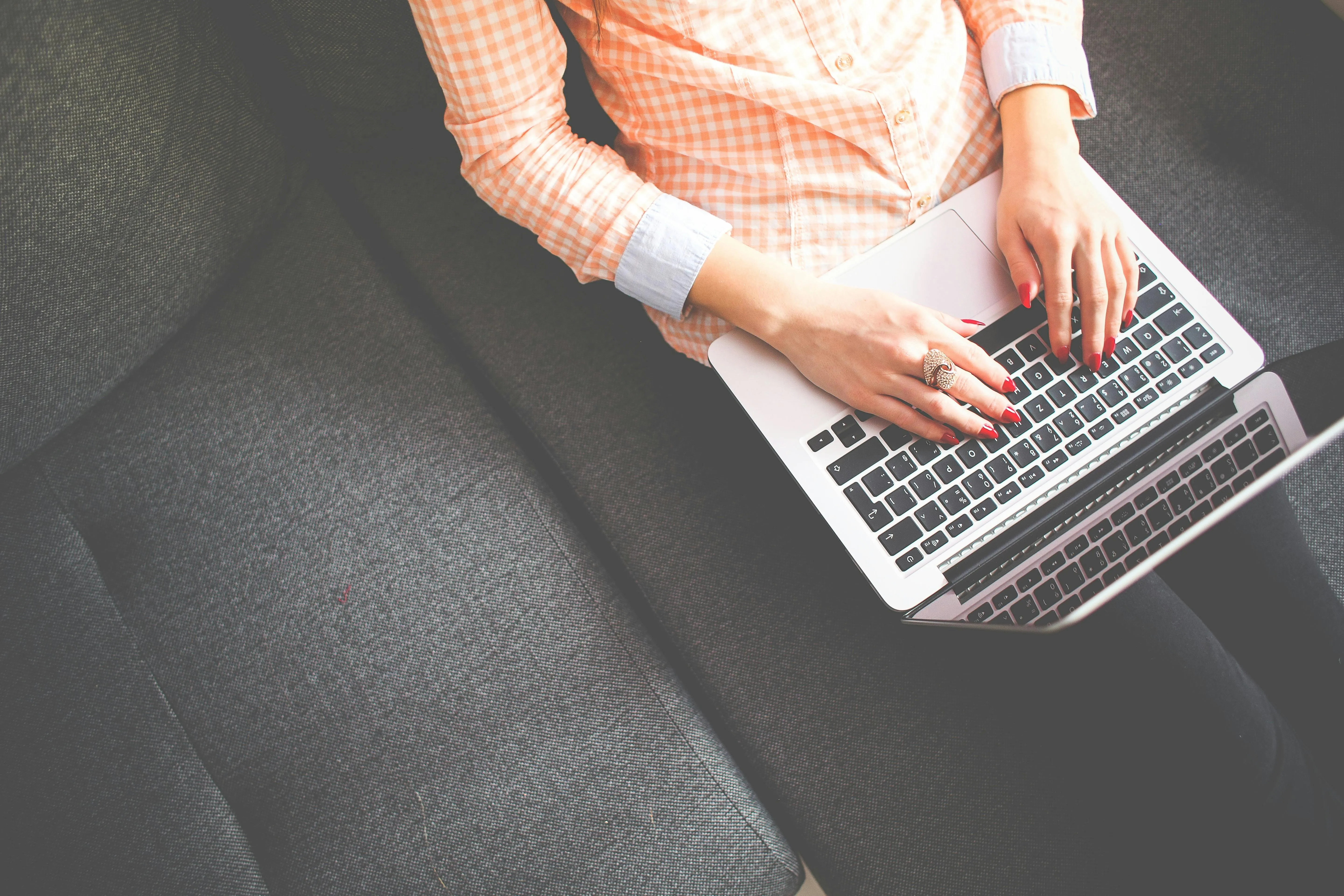 Female sat on a sofa using a laptop