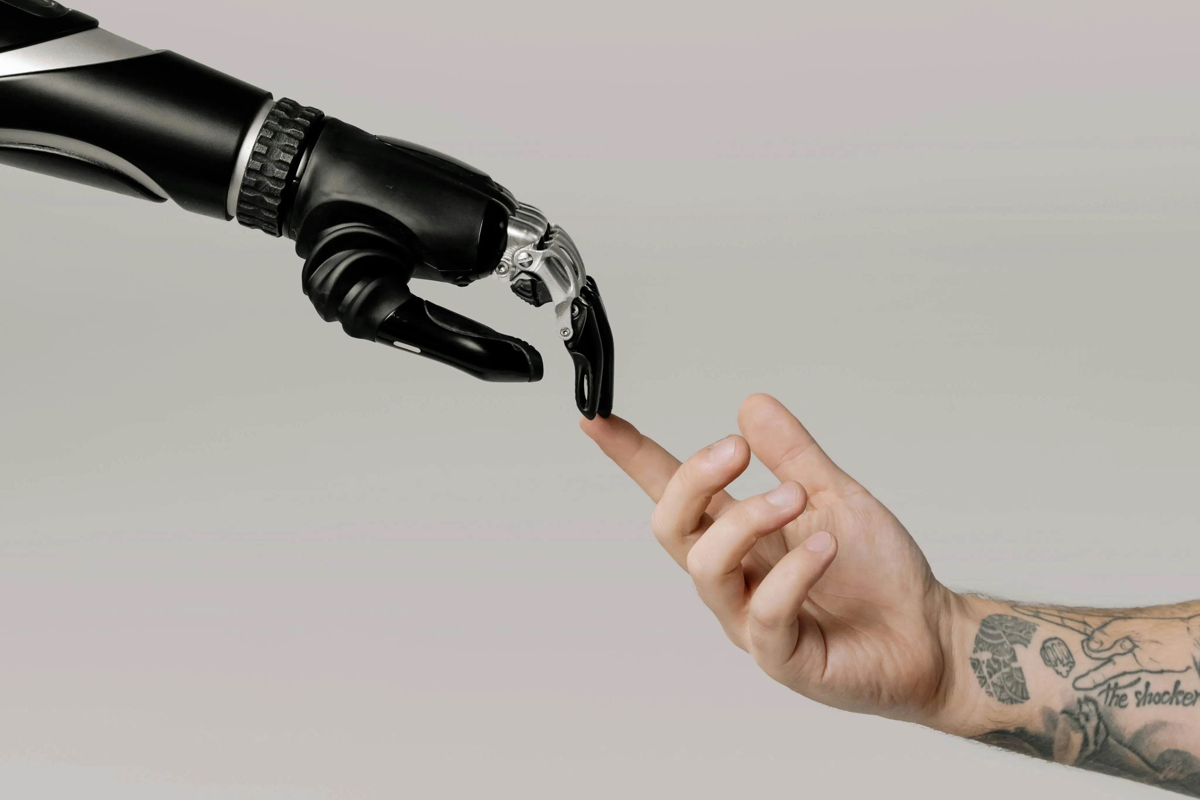Human hand touching the a robot hand with its index finger