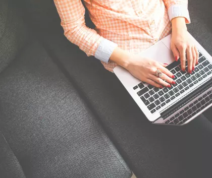 Female sat on a sofa using a laptop