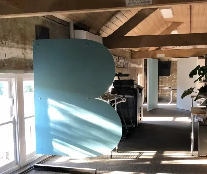 Large letter B metal sculpture in a room 